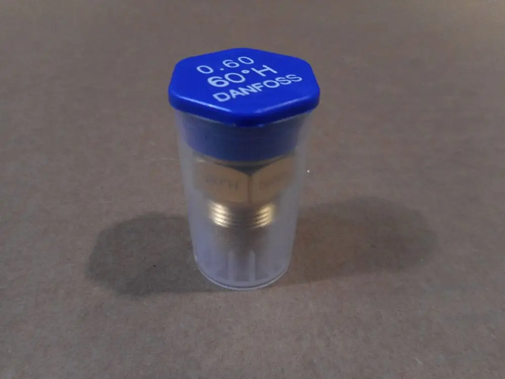 Transparente Verpackung mit einer Düse von Remeha. Der obere Teil ist blau mit weißen Schriftzügen; die Düse selbst hat goldene Metallkomponenten.